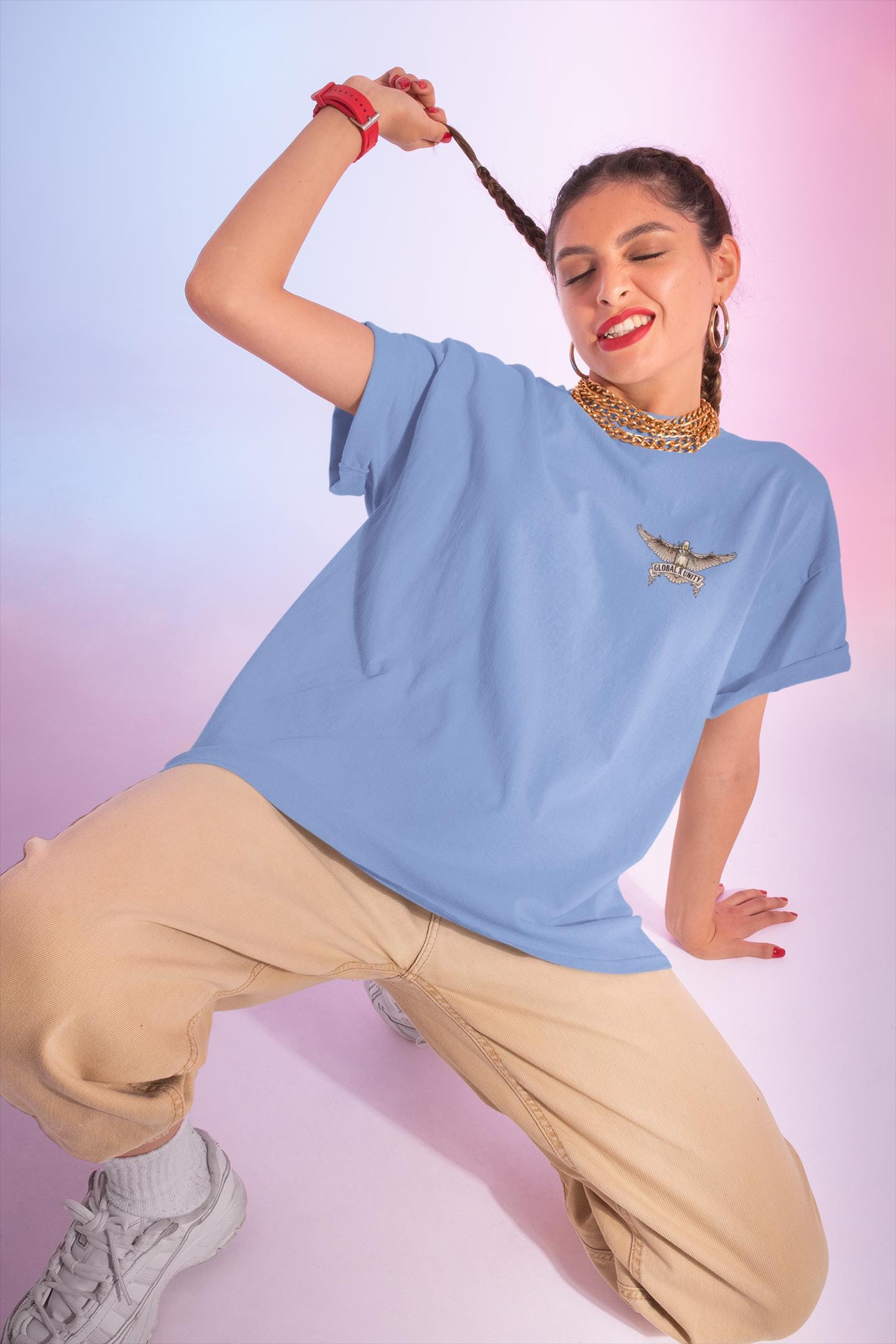 Woman wearing a light blue t-shirt with a logo and beige pants against a gradient background